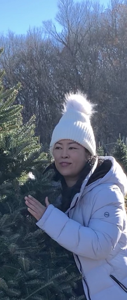 student standing next to christmas tree